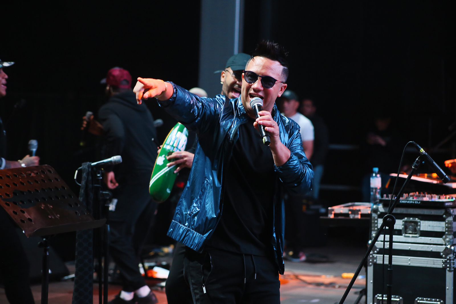 Maykel Blanco cantando y señalando al público durante un concierto